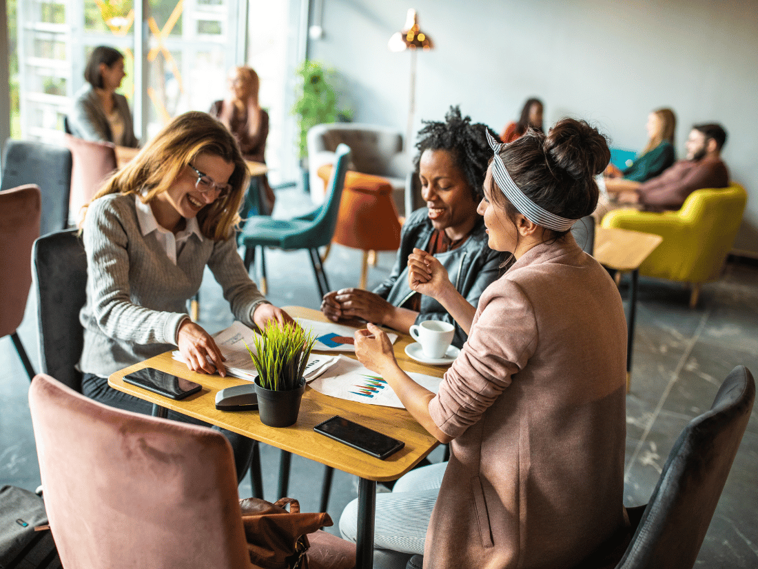 Three coworkers chatting over coffee